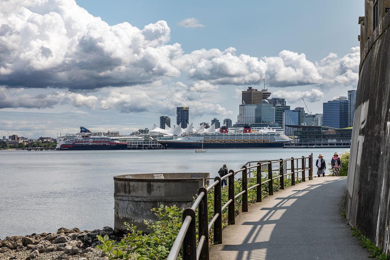 The Stanley Park seawall curving along the water with the city beyond